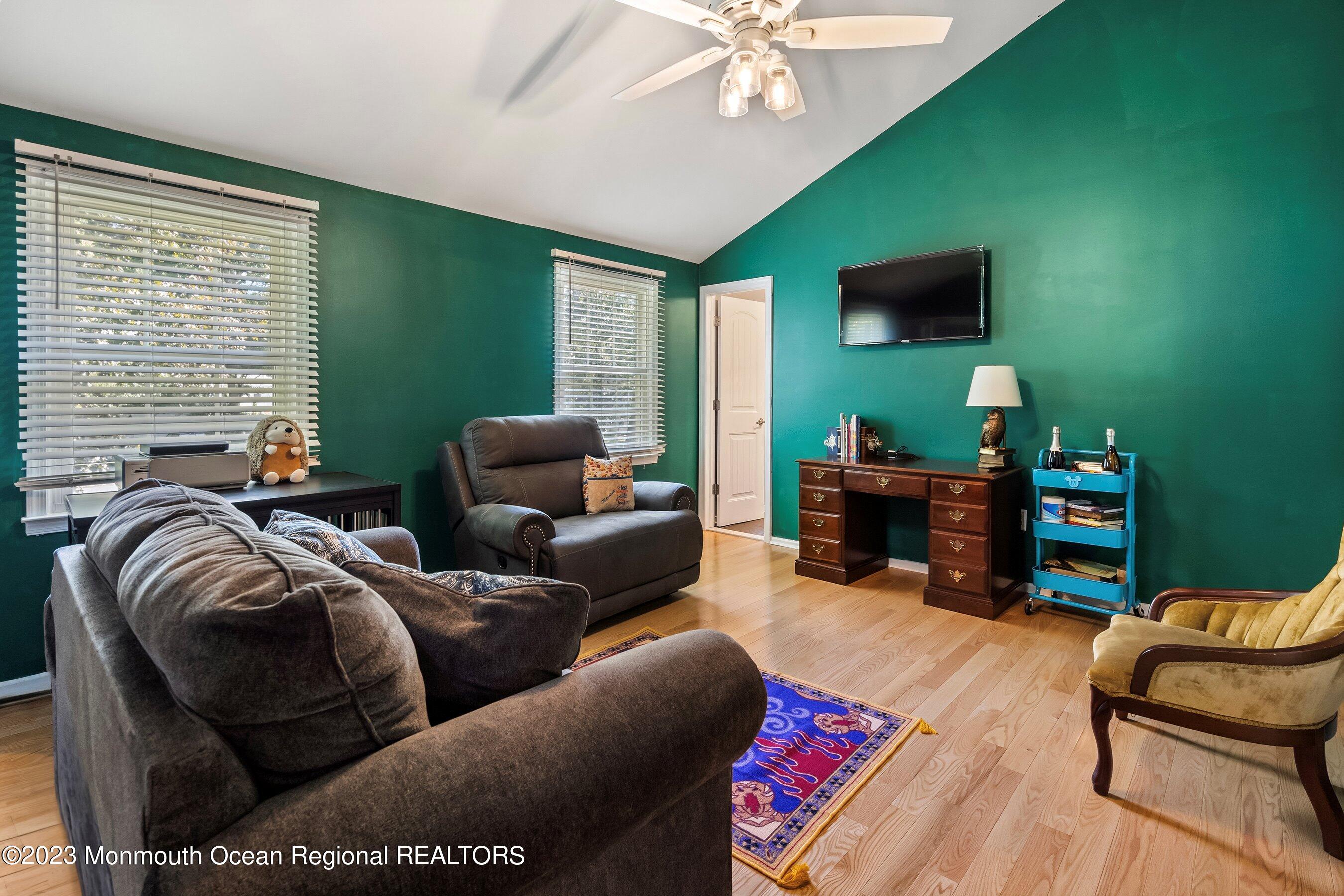 3 Adams Court Howell, NJ 07731 - Photo 23 of 36 a living room with furniture a flat screen tv and a window