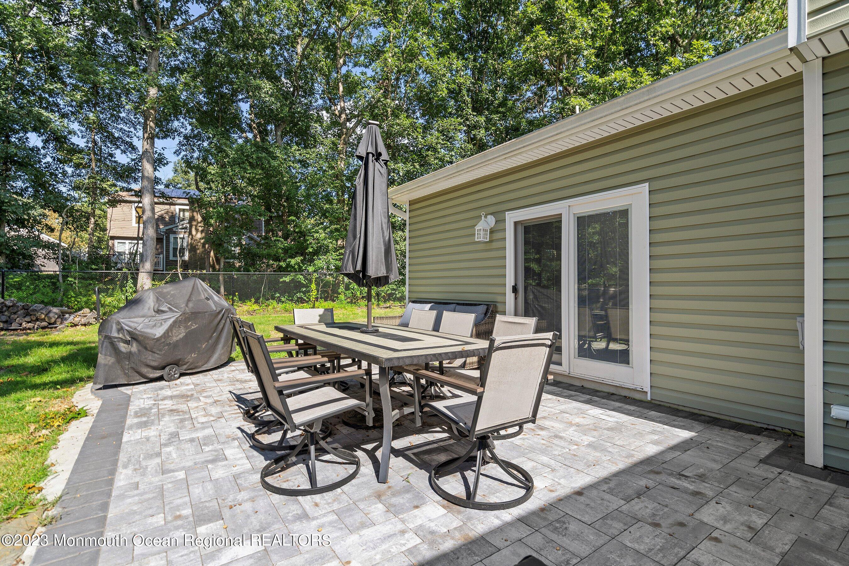 3 Adams Court Howell, NJ 07731 - Photo 31 of 36 a view of a dinning table and chairs in backyard of the house
