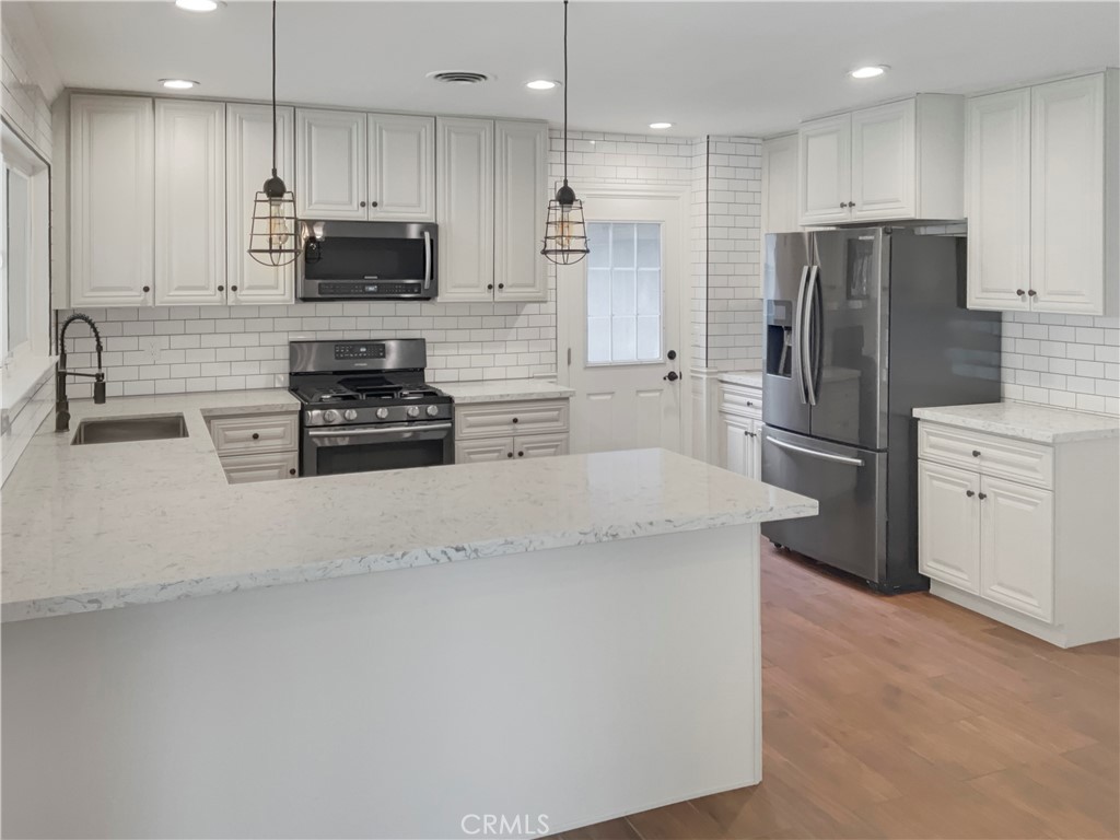 6376 Westview Drive Riverside, CA 92506 - Photo 11 of 23 a kitchen with stainless steel appliances granite countertop a refrigerator a stove a sink and a microwave