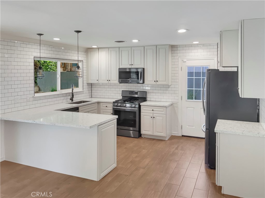 6376 Westview Drive Riverside, CA 92506 - Photo 6 of 23 a kitchen with stainless steel appliances a stove a sink a refrigerator and a oven