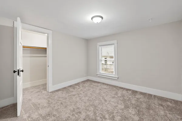 an empty room with windows and closet
