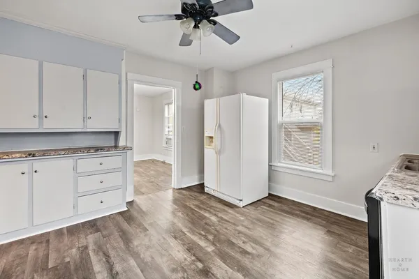 a view of kitchen with granite countertop cabinets and window