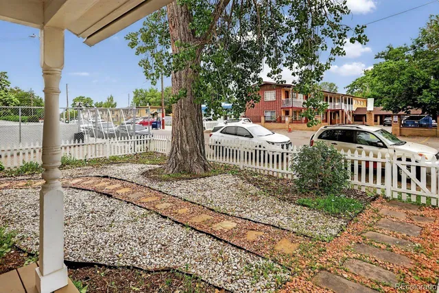 a view of a brick house with a small yard and plants