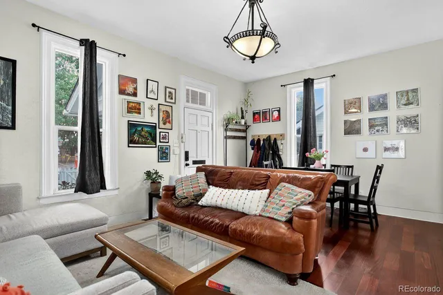 a living room with furniture a flat screen tv and a table