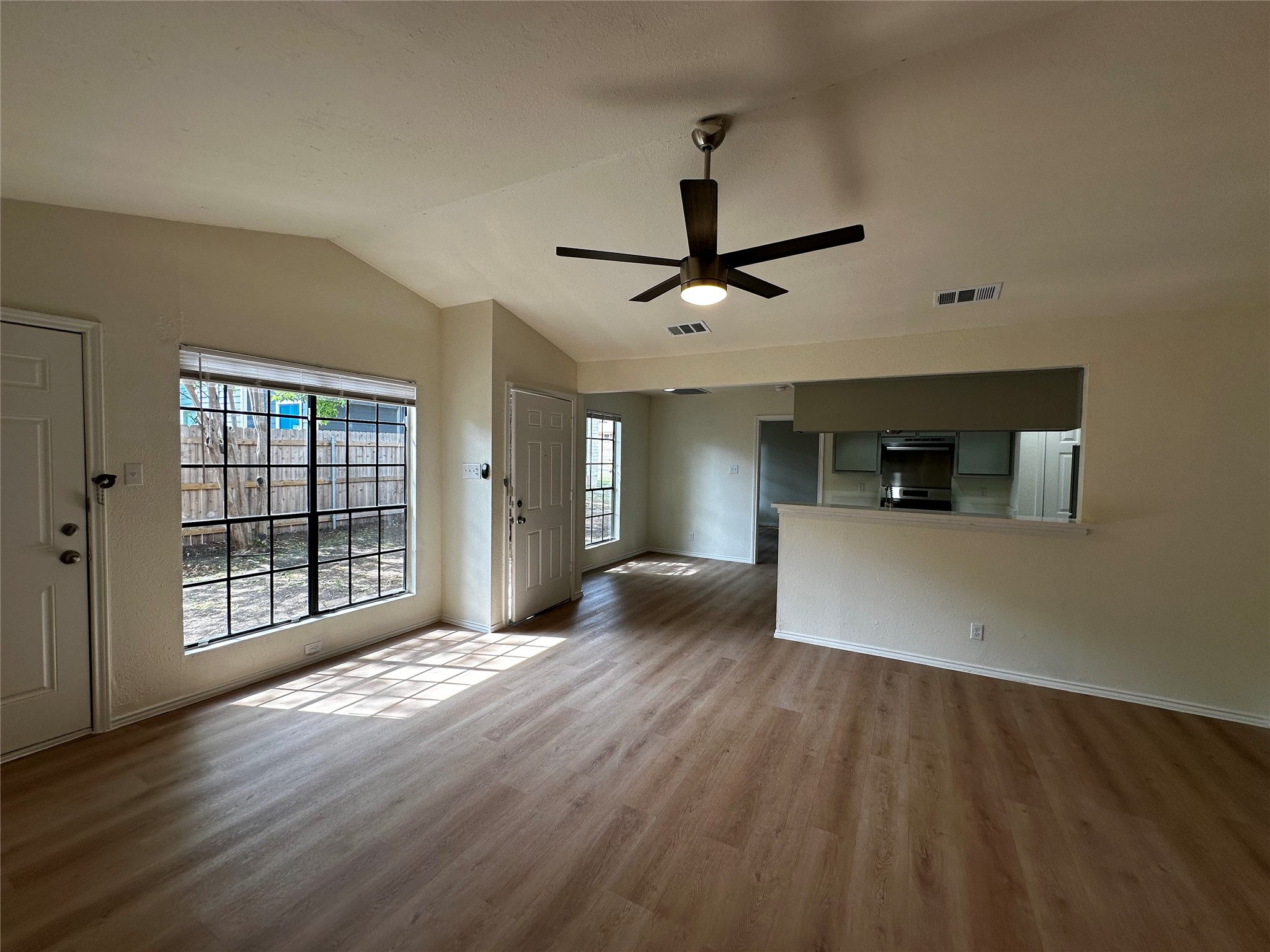 8809 Cainwood Lane Austin, TX 78729 - Photo 12 of 27 a view of an empty room with wooden floor and a window