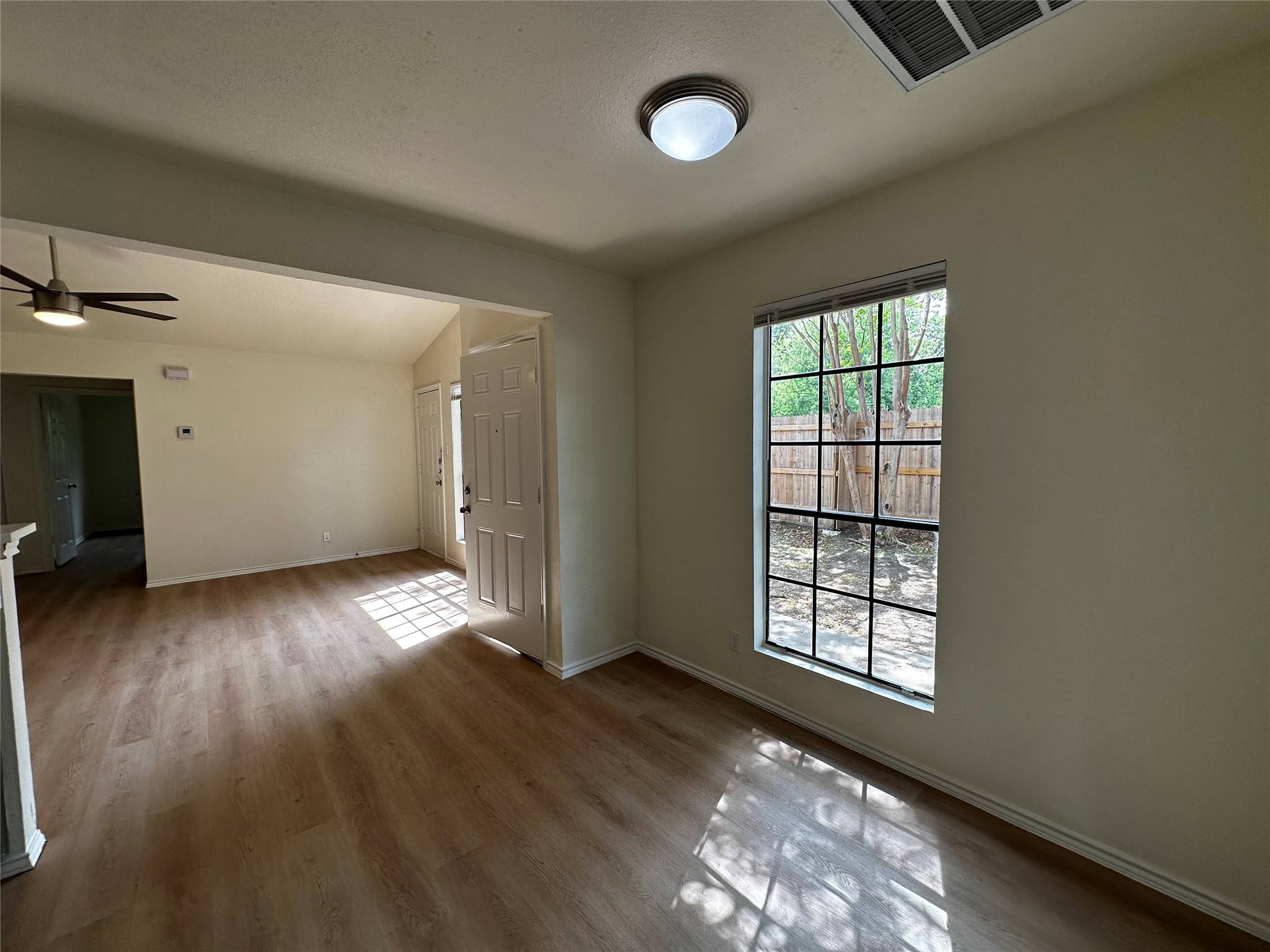 8809 Cainwood Lane Austin, TX 78729 - Photo 14 of 27 an empty room with wooden floor and windows