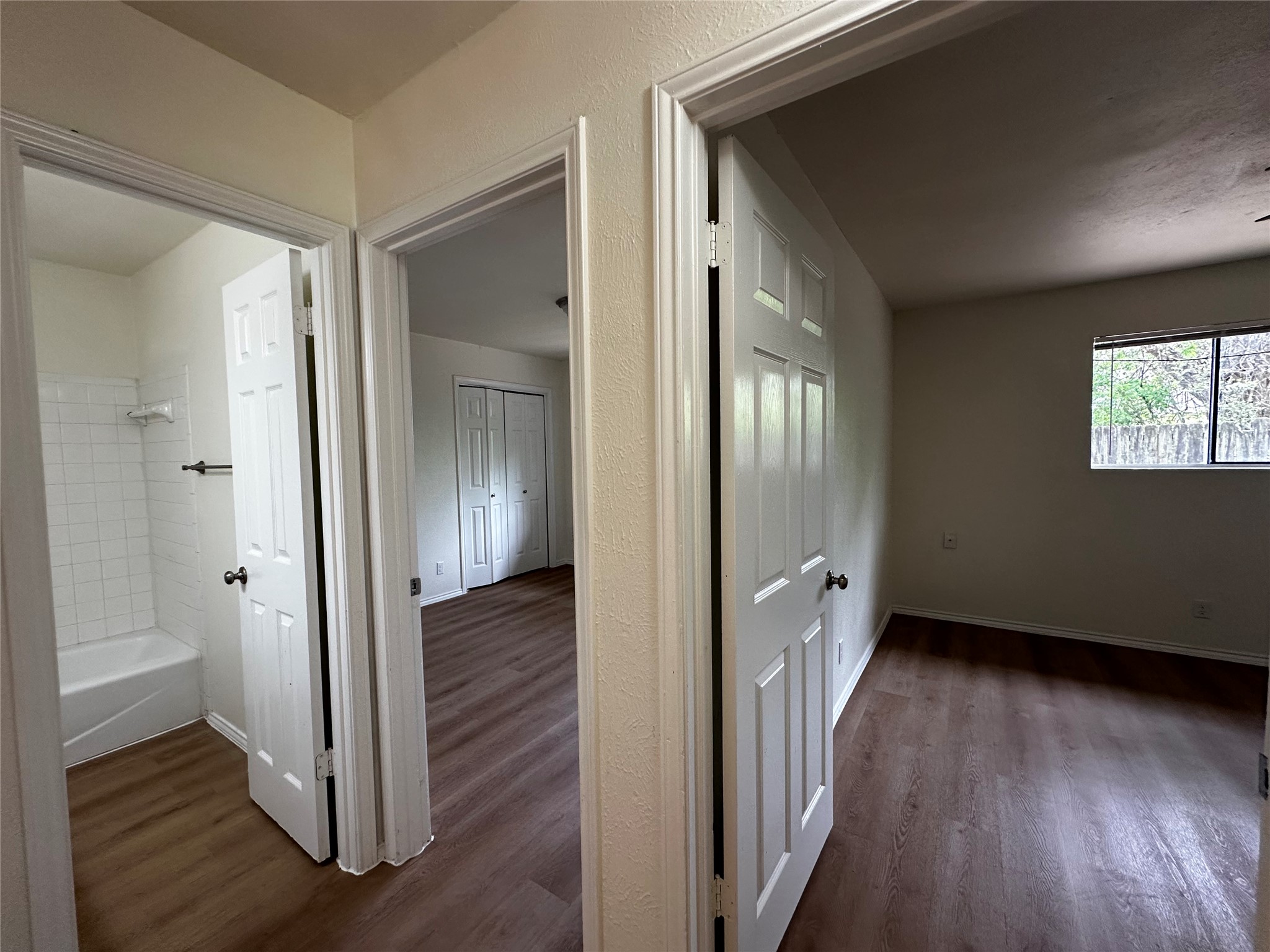 8809 Cainwood Lane Austin, TX 78729 - Photo 23 of 27 a view of an empty room with wooden floor and a bathroom