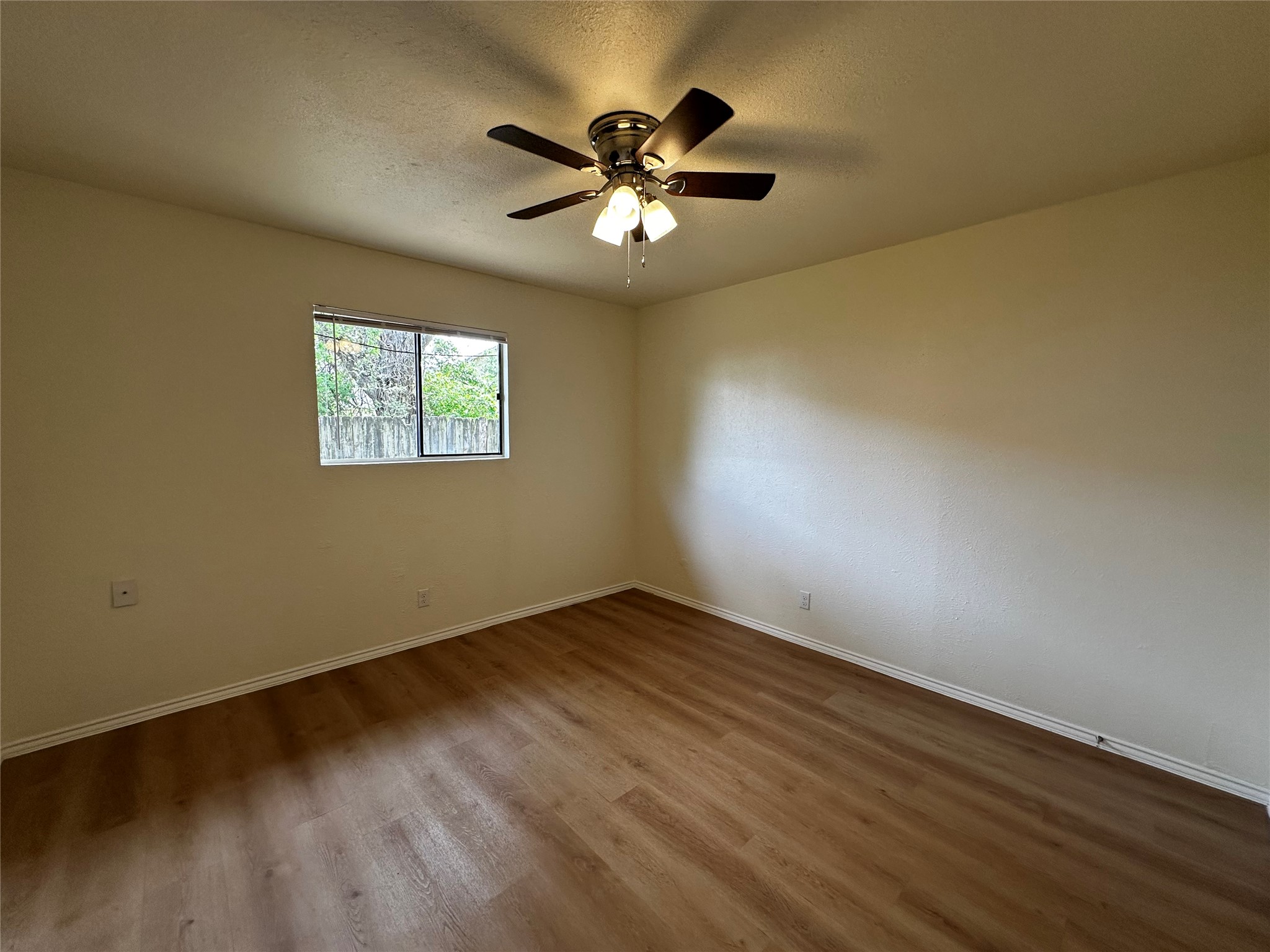 8809 Cainwood Lane Austin, TX 78729 - Photo 24 of 27 a view of an empty room with wooden floor and a ceiling fan