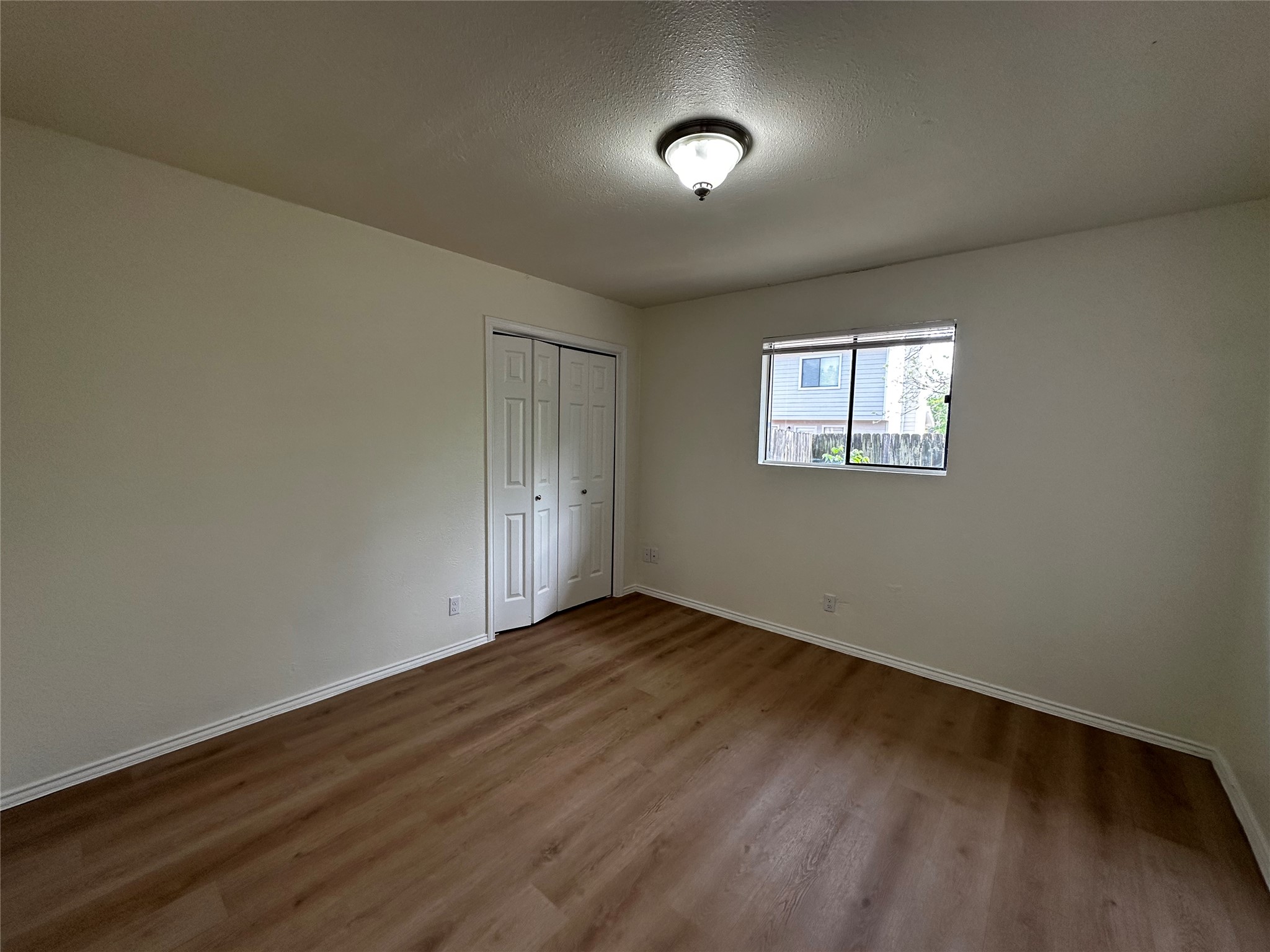 8809 Cainwood Lane Austin, TX 78729 - Photo 25 of 27 an empty room with wooden floor and windows