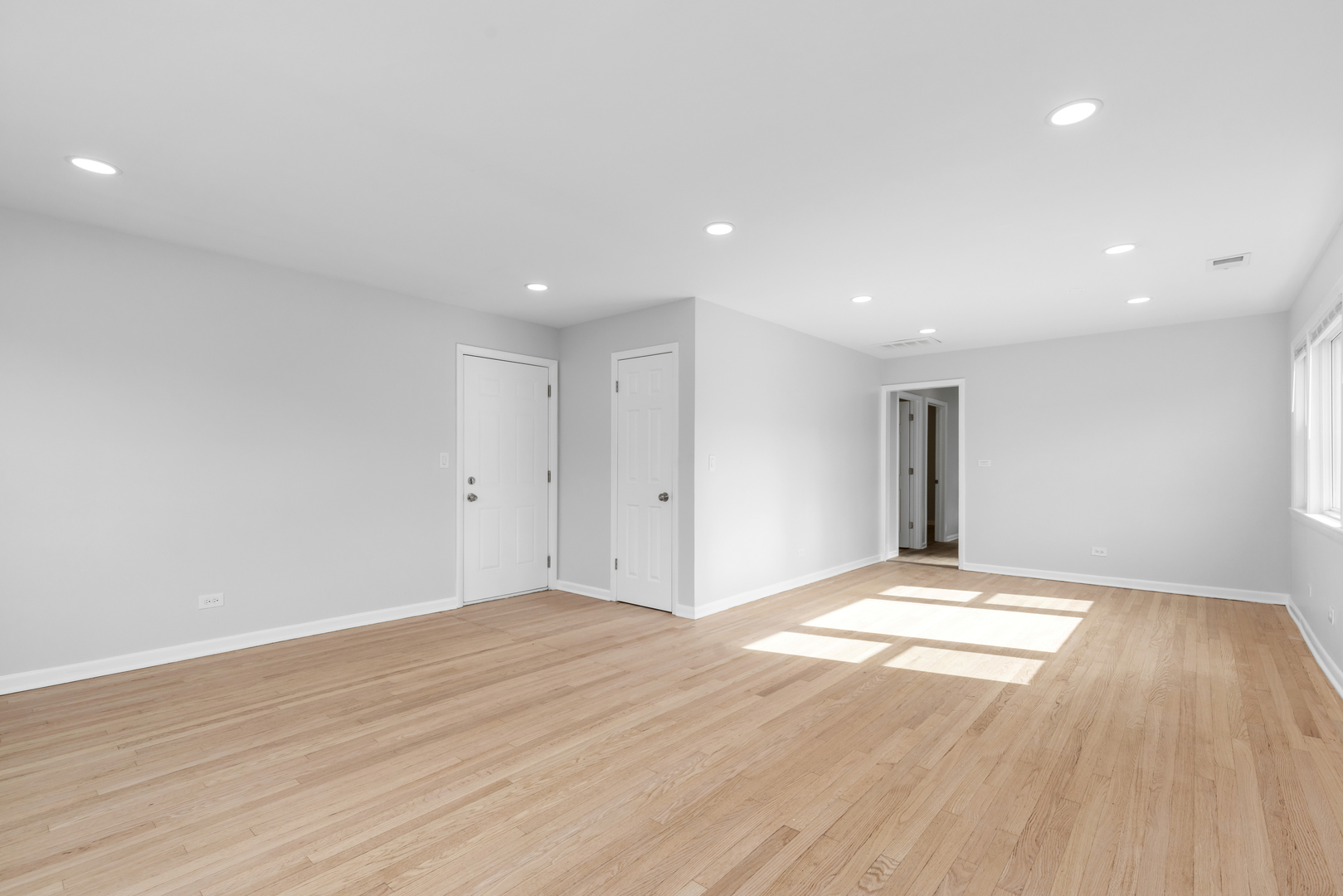 135 Custer Avenue, Unit 3 Evanston, IL 60202 - Photo 9 of 18 a view of an empty room with wooden floor and a window