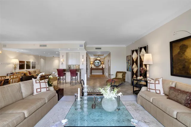 a view of a hallway to a livingroom with a dining table & chairs