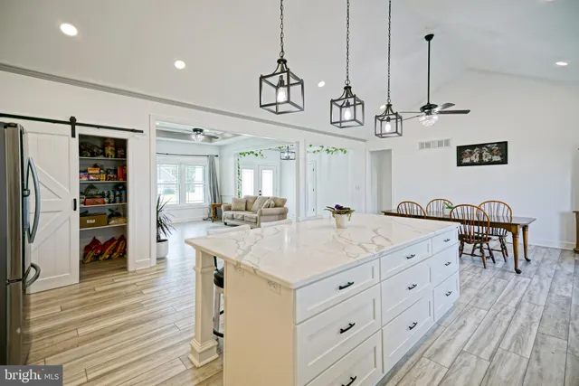 a kitchen with stainless steel appliances granite countertop a kitchen island a stove and a wooden floors