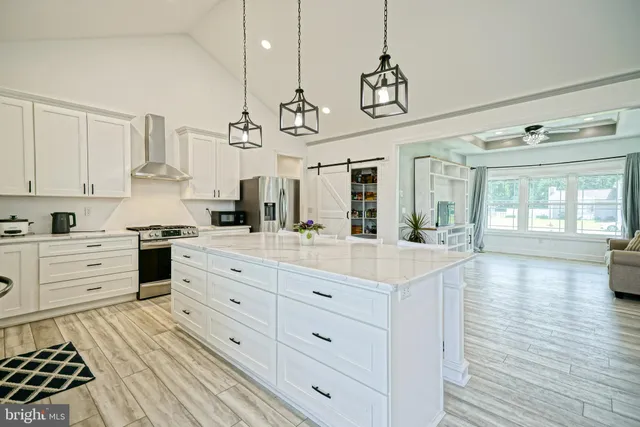 a kitchen with stainless steel appliances kitchen island granite countertop a stove a sink and a wooden floors