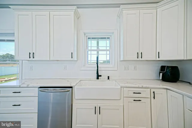 a kitchen with white cabinets and a sink
