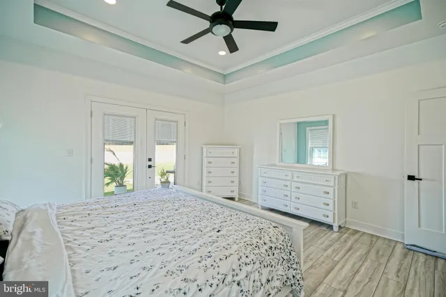 a bedroom with a bed chandelier and a window
