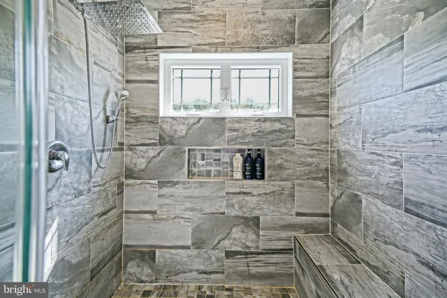 a bathroom with a granite countertop shower a mirror and a sink