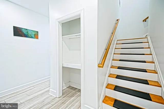 a view of a bedroom with wooden floor and staircase