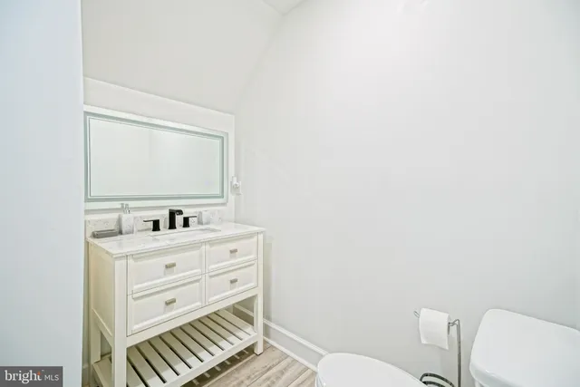 a bathroom with a toilet a sink a vanity and mirror
