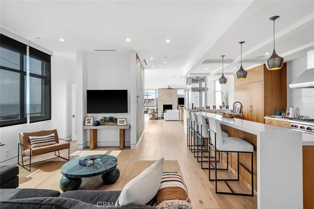 a living room with furniture a flat screen tv and kitchen view