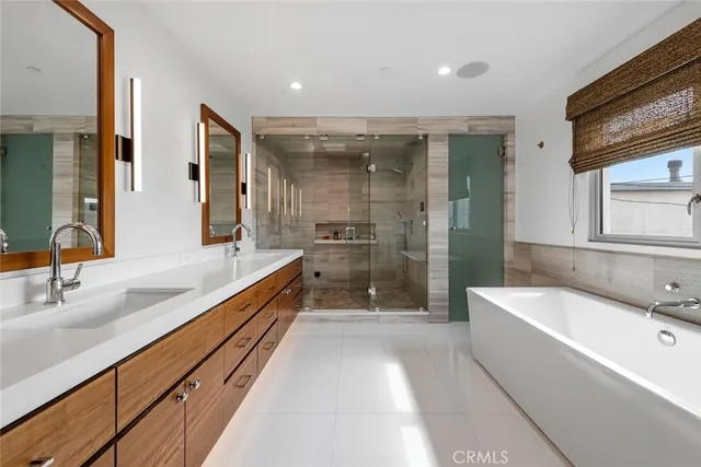a bathroom with a granite countertop tub sink and mirror