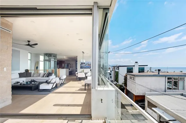a living room with stainless steel appliances furniture and a kitchen view