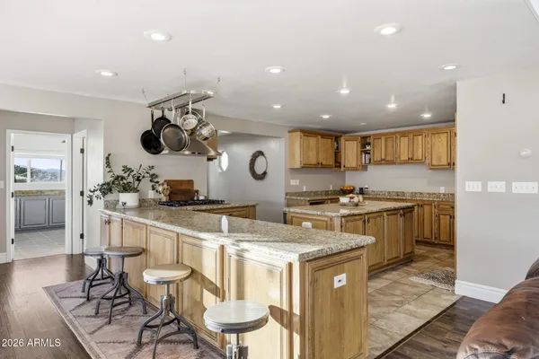 a kitchen with stainless steel appliances granite countertop a sink dishwasher and cabinets with wooden floor