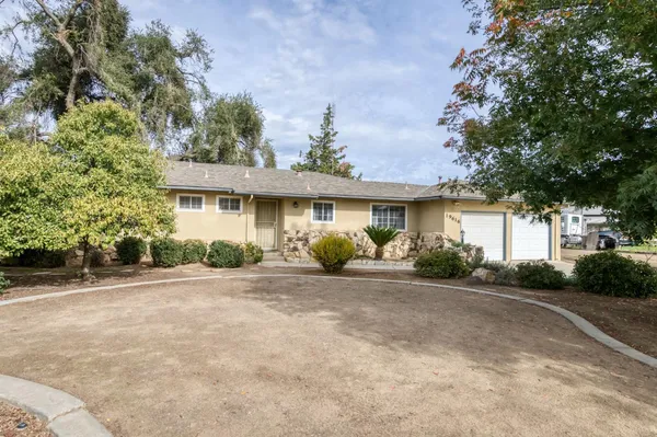 a front view of a house with a yard and potted plants