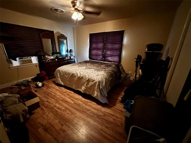 a bedroom with a bed dresser and a flat tv screen