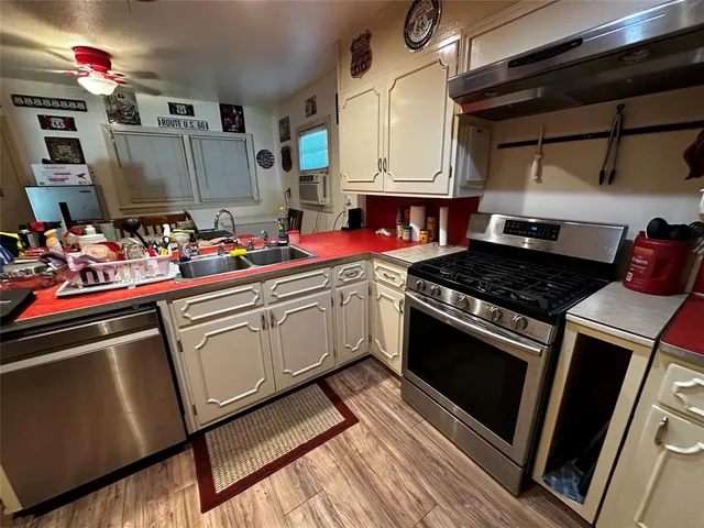 a kitchen with stainless steel appliances a sink dishwasher stove and cabinets
