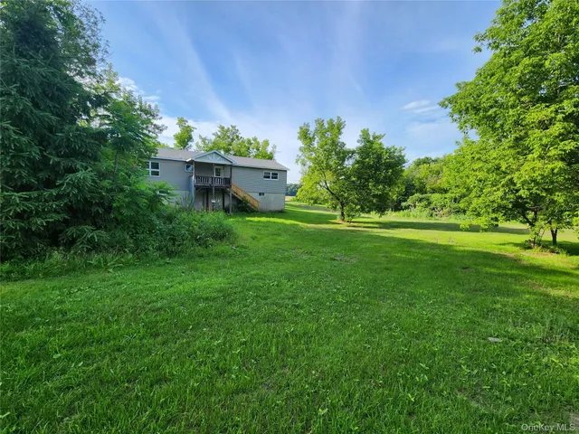a backyard of a house with lots of green space and garden
