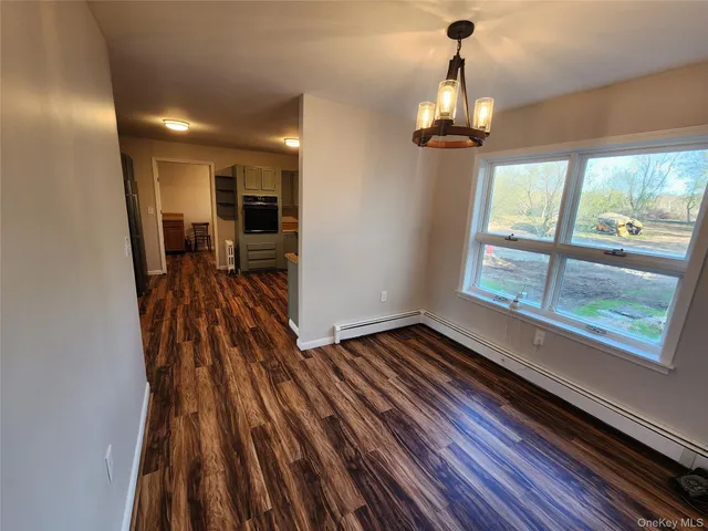 a view of a room with wooden floor and a window