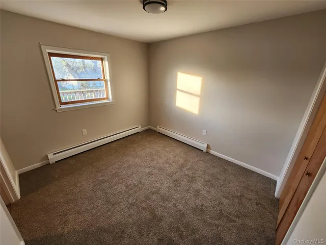 an empty room with windows and closet