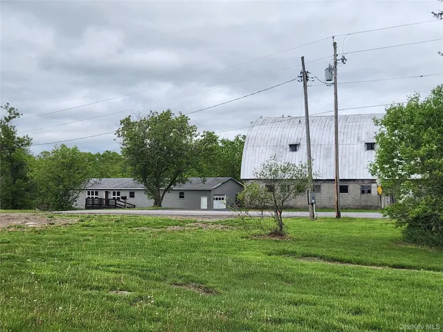 a view of a house with pool and a yard
