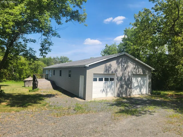 a view of a house with backyard and a tree