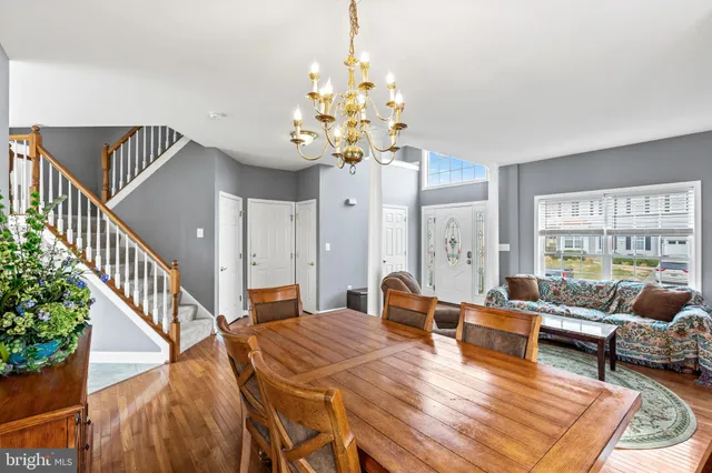 a living room with furniture dining table a chandelier and a rug