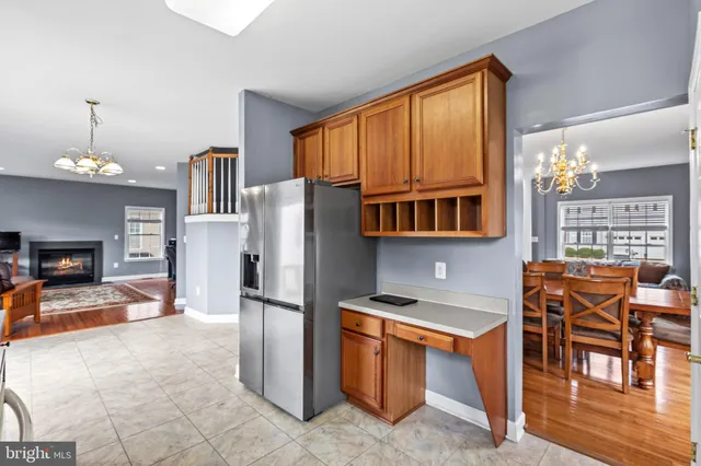 a kitchen with stainless steel appliances granite countertop a refrigerator a stove a kitchen island a dining table and chairs