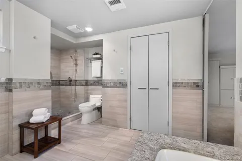 a bathroom with a granite countertop sink a toilet and shower