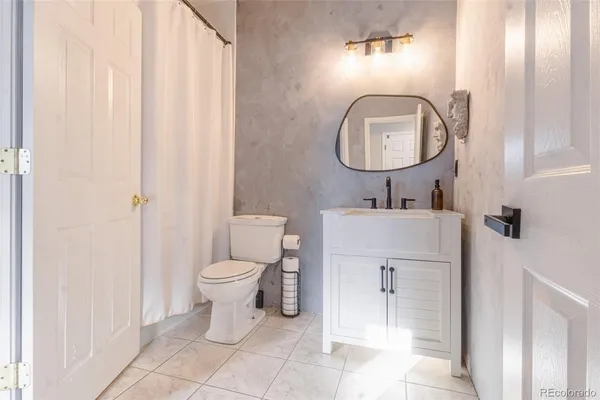 a bathroom with a toilet sink and mirror