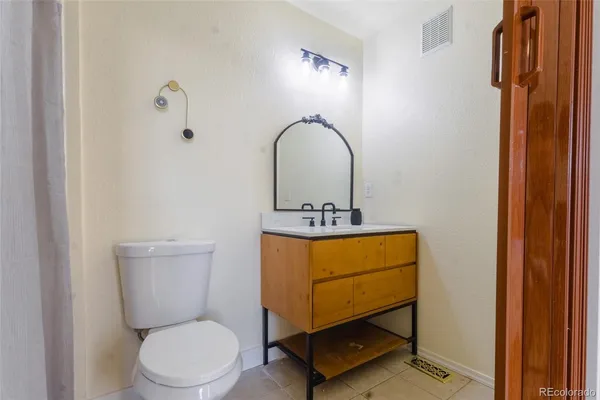 a bathroom with a toilet a sink and mirror