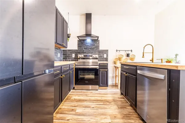 a kitchen with stainless steel appliances granite countertop a stove a sink and a refrigerator