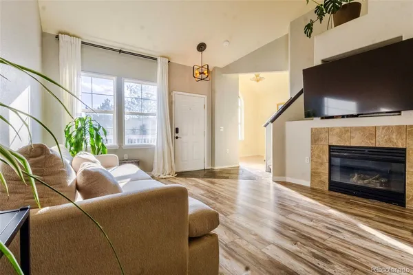 a living room with furniture a flat screen tv and a fireplace