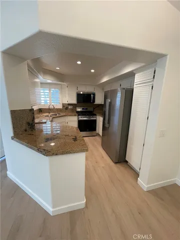 a kitchen with stainless steel appliances granite countertop a refrigerator a sink a stove a microwave and island