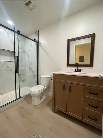 a bathroom with a toilet a sink a mirror and a shower