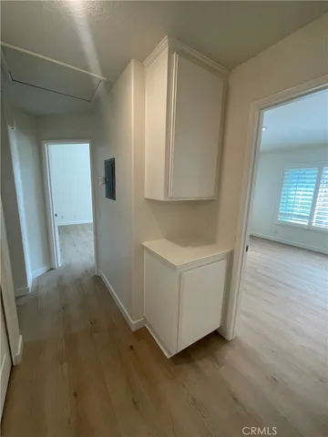 an entryway with wooden floor and cabinet