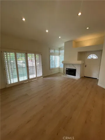 a view of an empty room with a fireplace and a window
