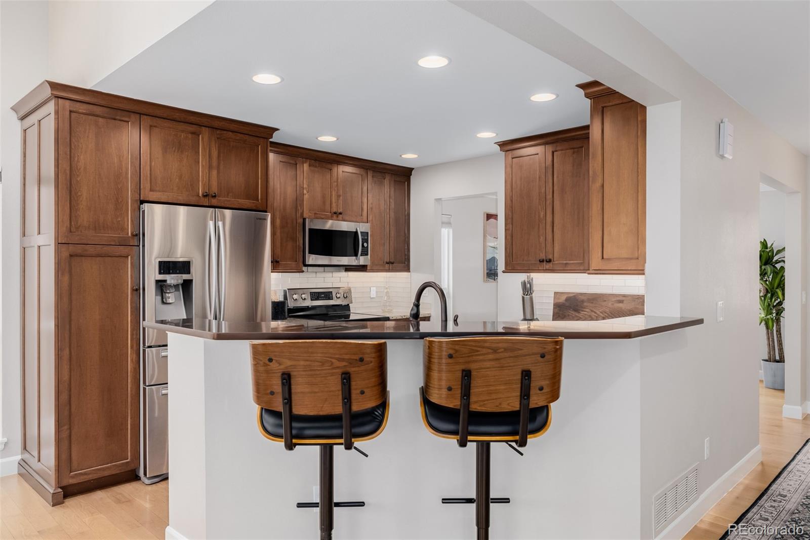 8827 South Cactus Flower Way Highlands Ranch, CO 80126 - Photo 15 of 49 a kitchen with stainless steel appliances granite countertop a refrigerator a sink and a stove with wooden floor