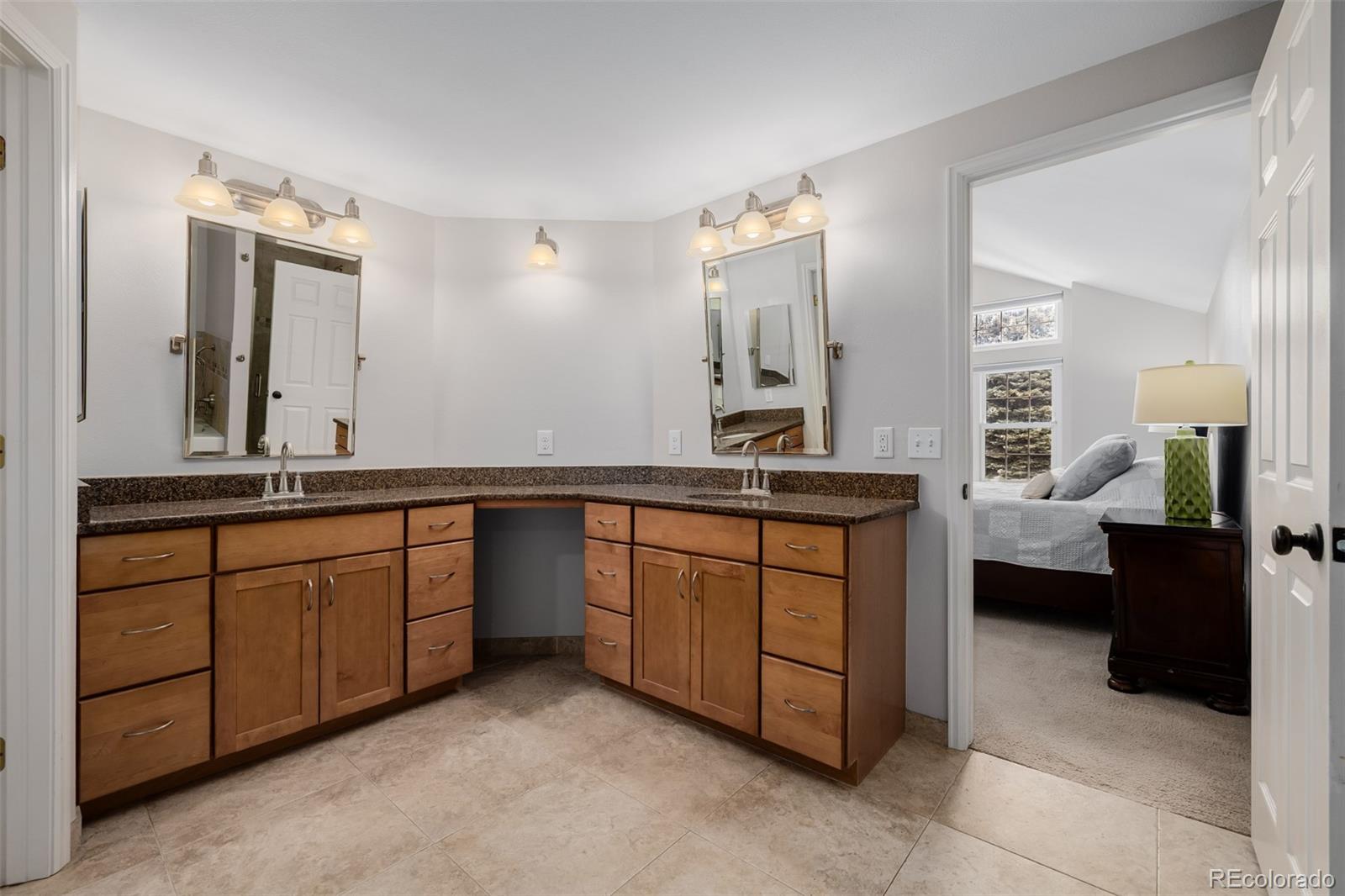 8827 South Cactus Flower Way Highlands Ranch, CO 80126 - Photo 26 of 49 a spacious bathroom with a granite countertop sink and a mirror