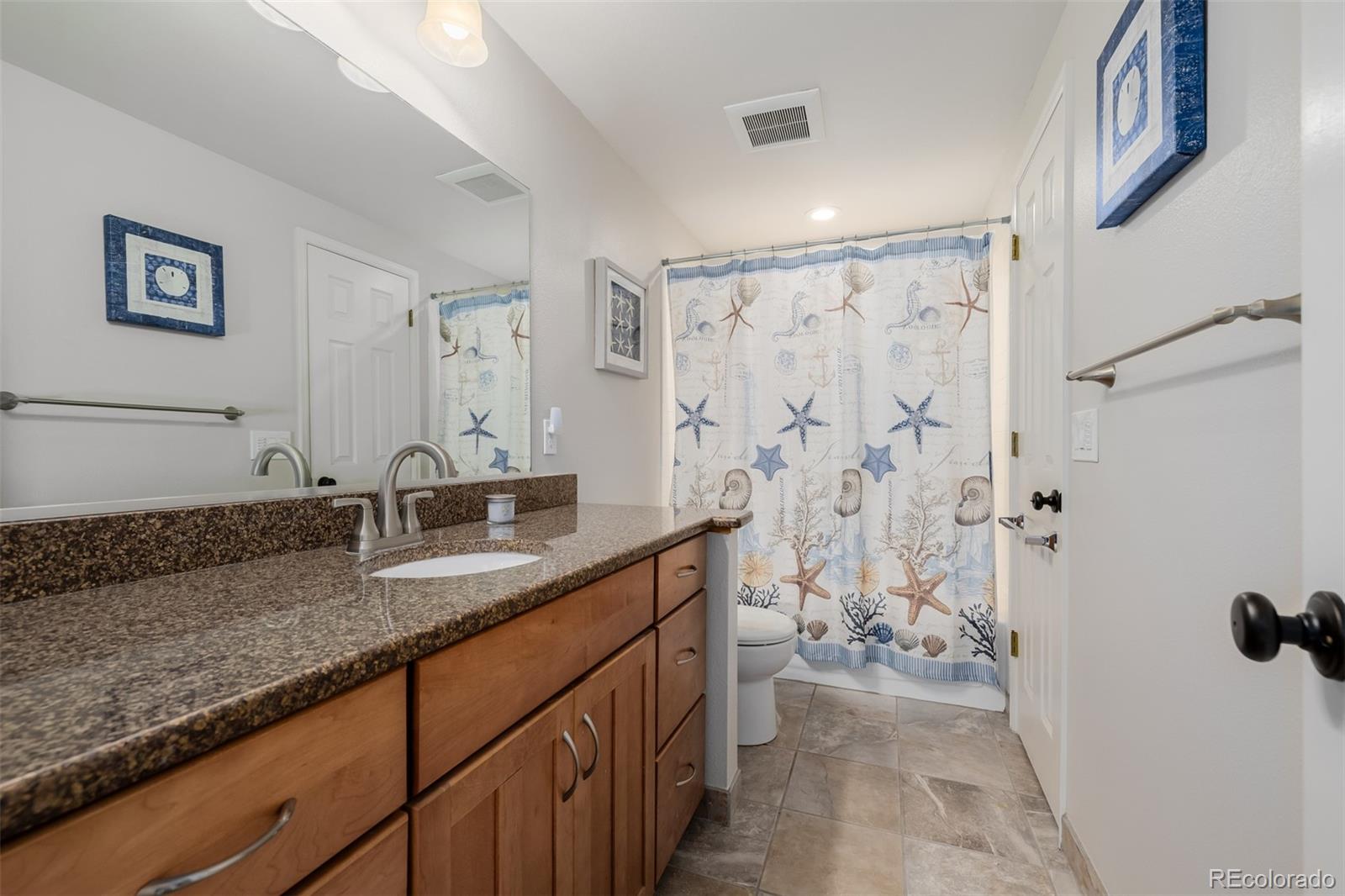 8827 South Cactus Flower Way Highlands Ranch, CO 80126 - Photo 34 of 49 a bathroom with a granite countertop sink a mirror and shower