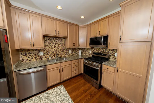 a kitchen with granite countertop a refrigerator stove and microwave