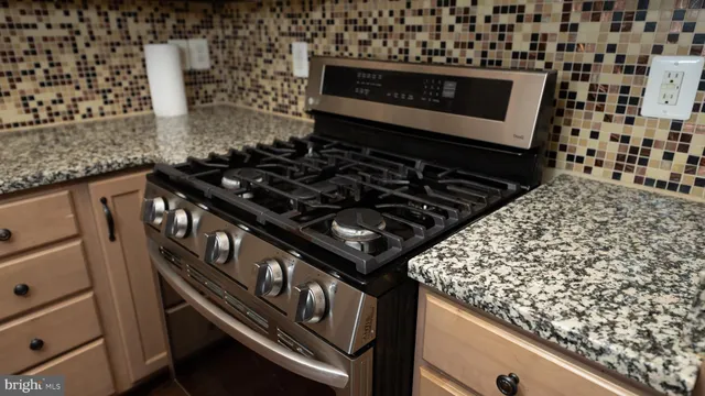 a stove sitting inside of a kitchen with granite countertop
